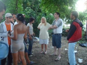 A group of people standing around in the woods.