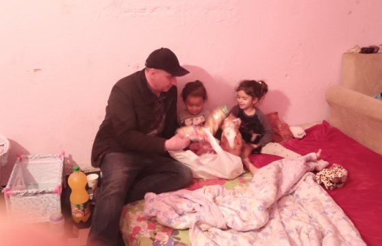 A man and two children sitting on the bed