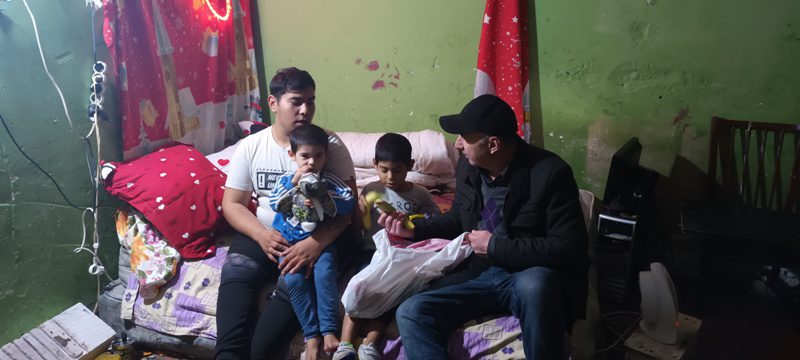 A man sitting on top of a couch next to two men.