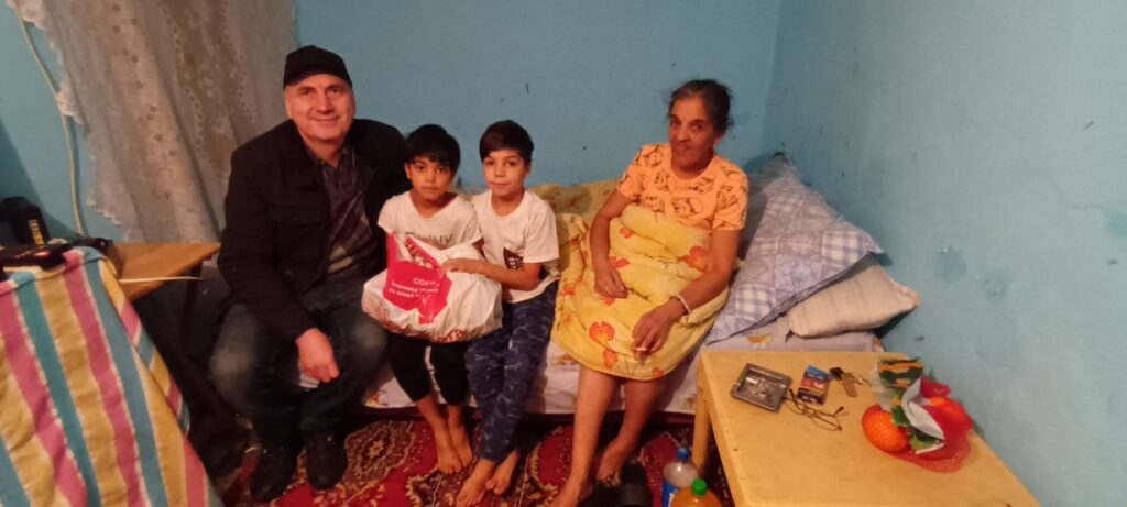 A family sitting on the floor in their room.