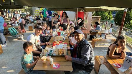 A group of people sitting at tables eating food.