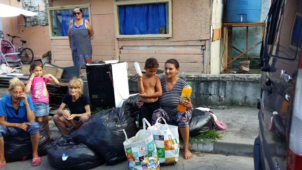A woman and two children sitting on the ground.