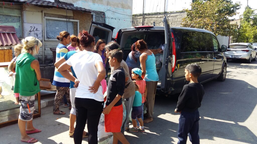 A group of people standing around an open van.