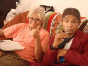 Smiling woman and man on crochet-covered sofa